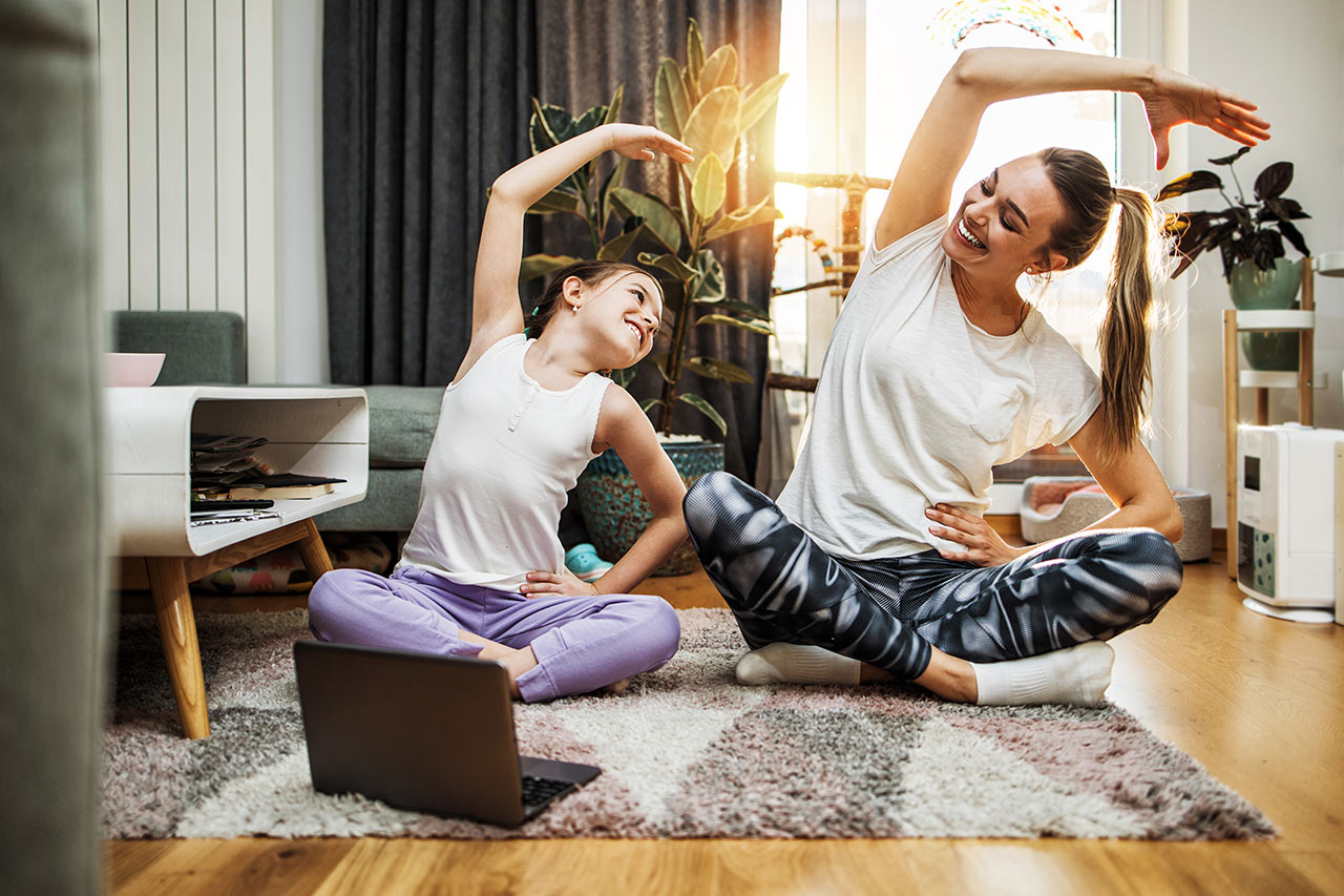 Anya és lánya boldogan jógázik a harmonikusan berendezett nappaliban